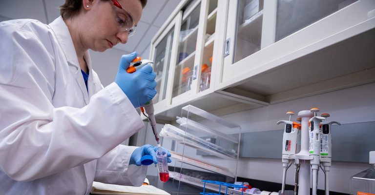 Scientist pipetting at the bench