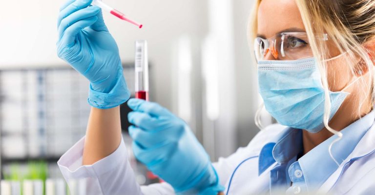 Scientist wearing gloves and mask with test tube