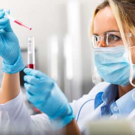 Scientist in Lab wearing mask and gloves