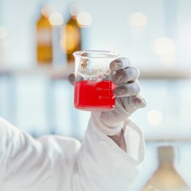 Scientist Holding a Beaker of Cell Culture Media