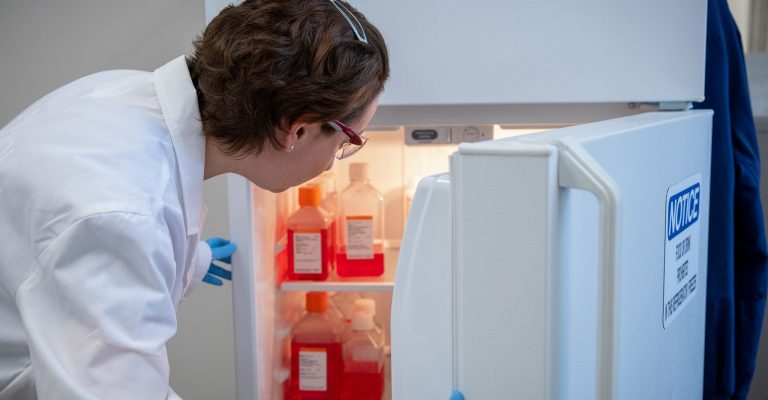 scientist looking in fridge for media