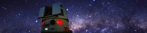 Image of the Lowell Telescope set against a starry night. 