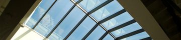 Looking up at blue sky through windows in peaked skylight