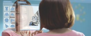 Girl views image of running shoe on large glass display