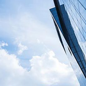 Looking up at sharp edges of tall building's multiple windows